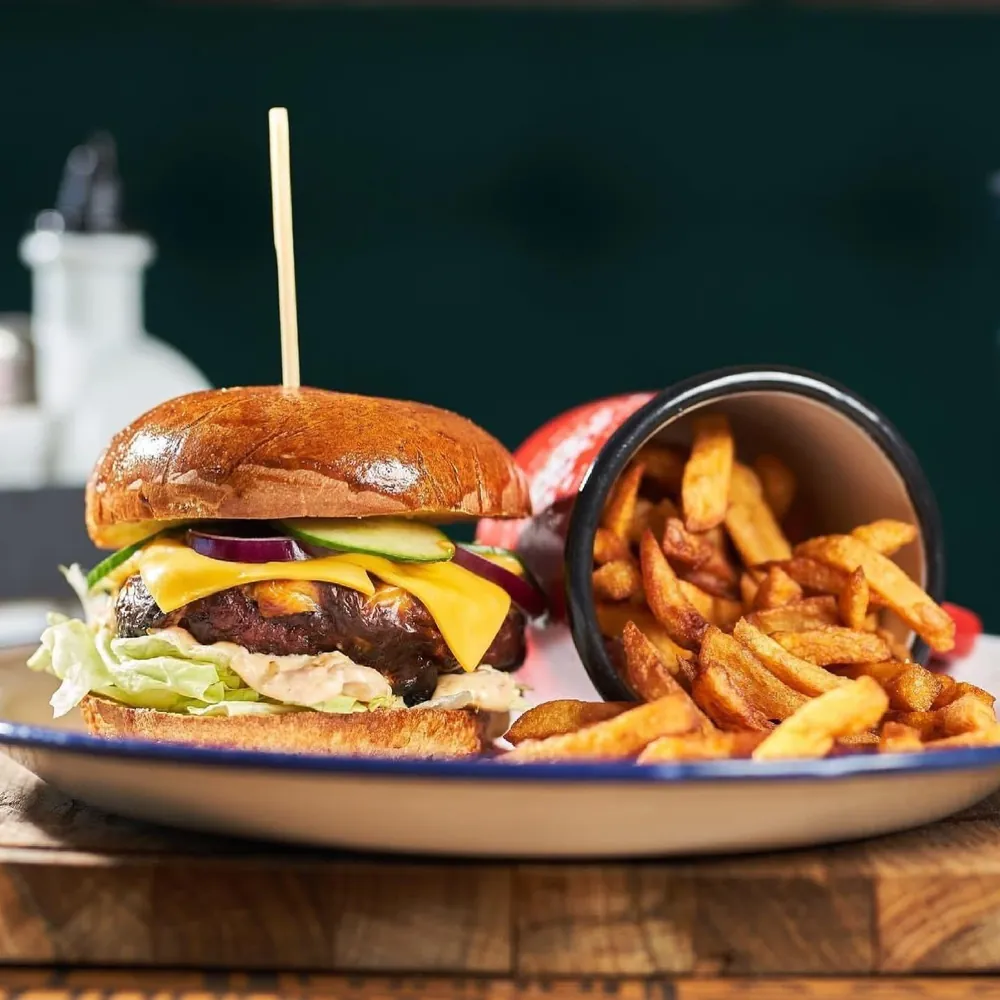 Cheeseburger cu cheddar, salată și castravete murat, cu cartofi prăjiți